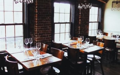 Empty Restaurant With Wooden Tables And Brick Wall
