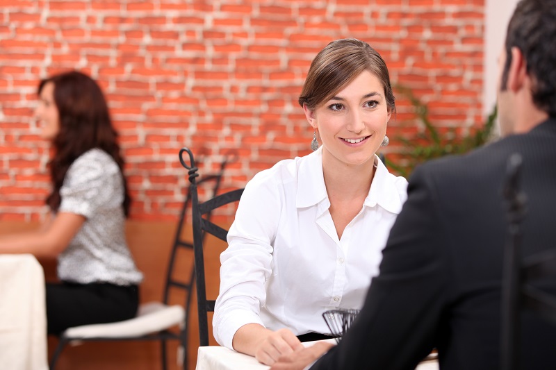 Waitress at an interview being questioned by a hiring manager. Flip Table blog about waitress interview questions.